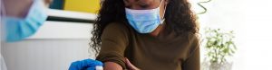 Woman wearing a protective mask getting vaccinated
